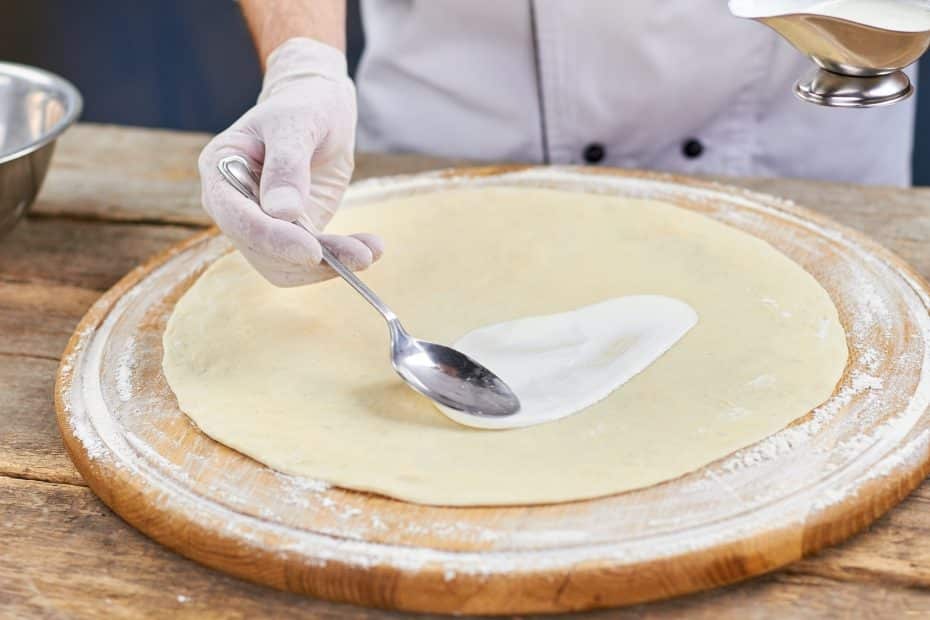 Hjemmelaget hvit pizzasaus smøres på bunnen